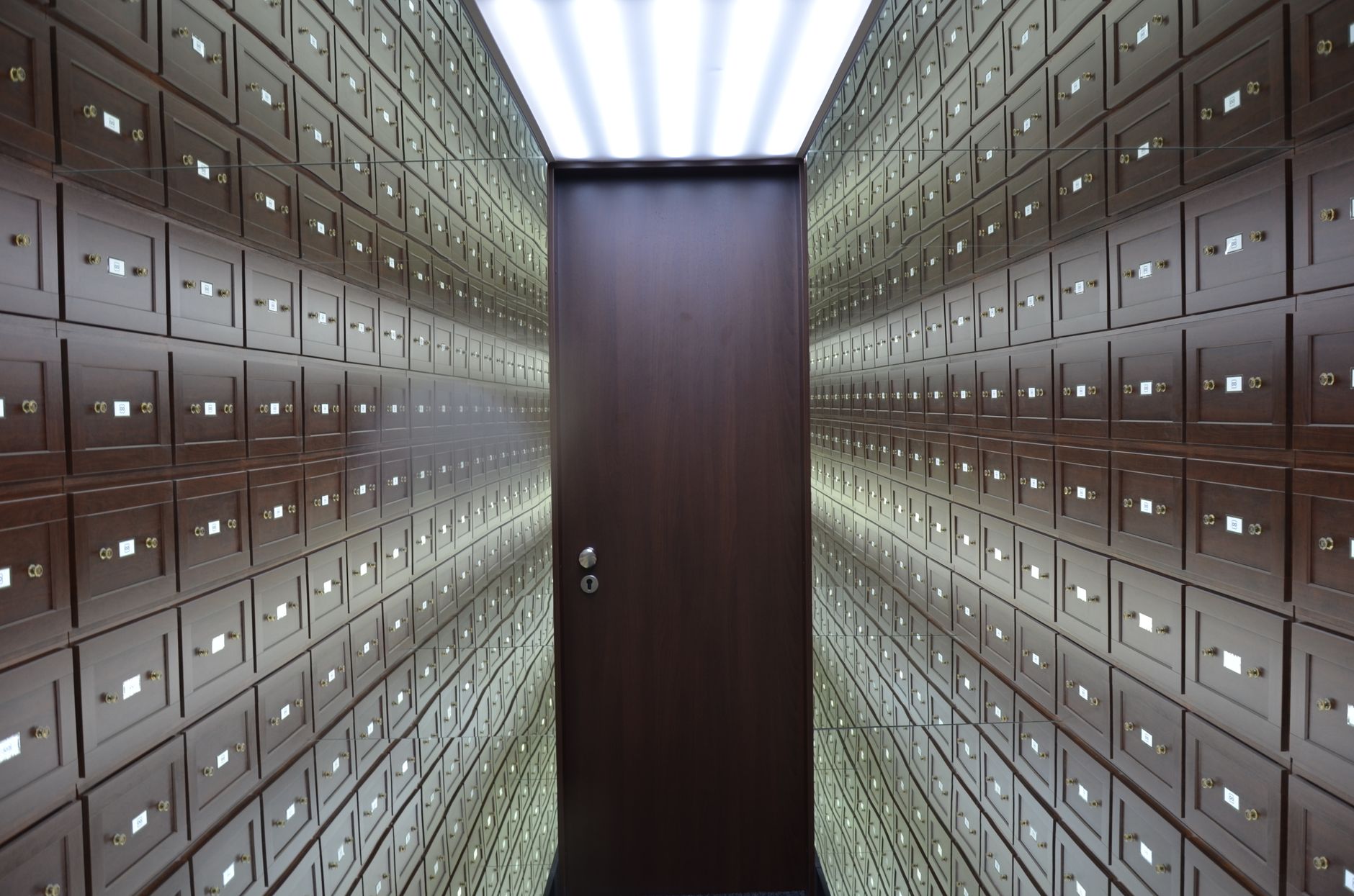 A row of old safe deposit boxes in a bank vault wall